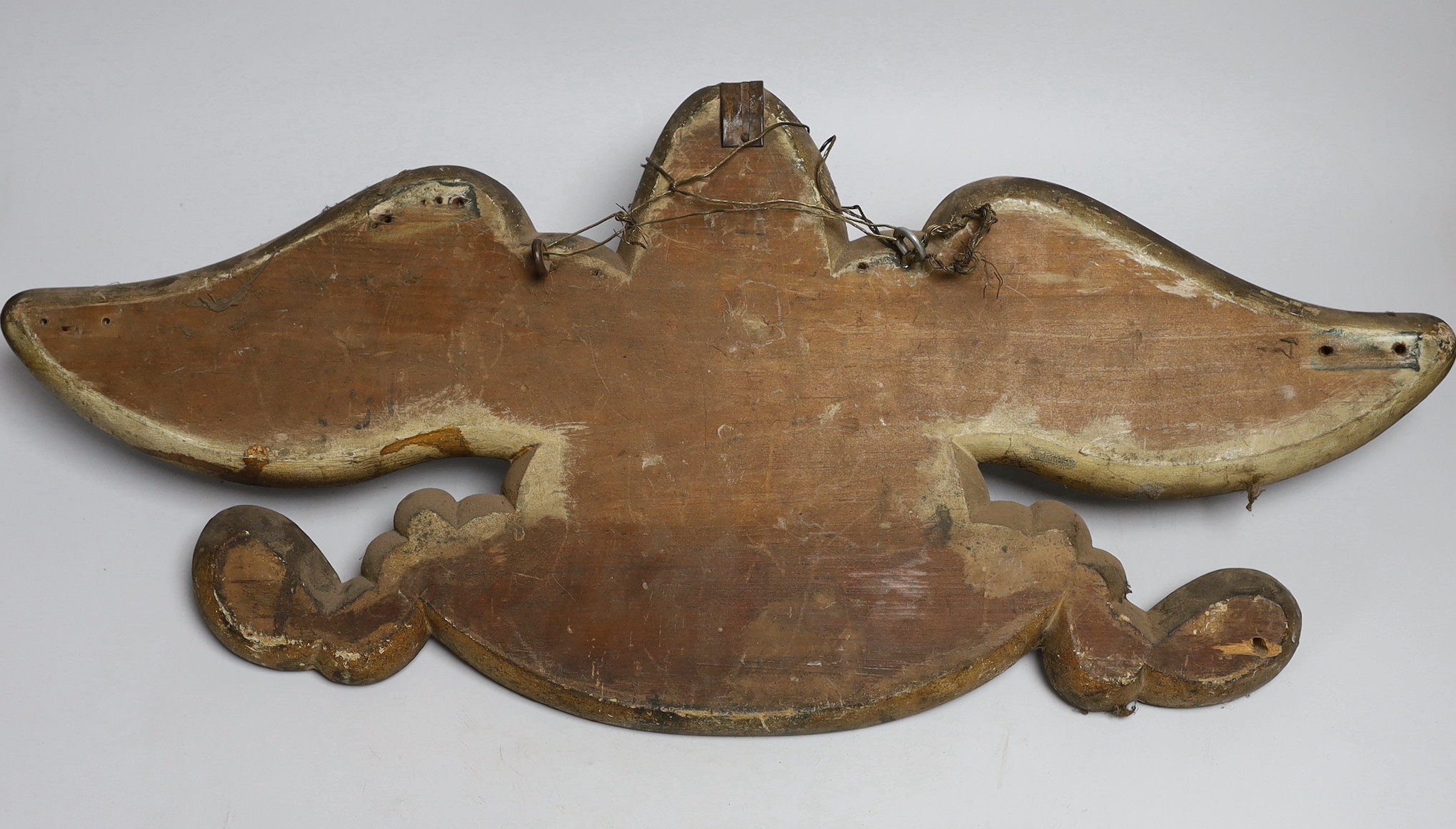 An American? painted metal eagle a on painted wooden mount, 60cms wide